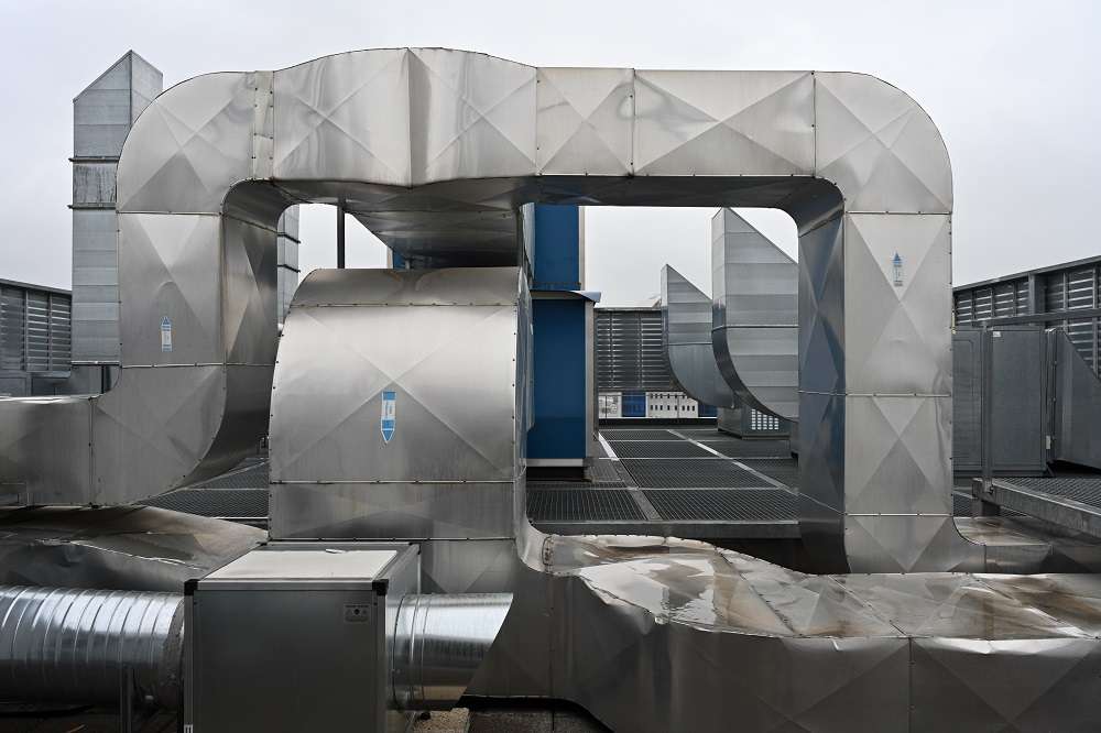 /> Compared to conventional ventilation, air handling ensures much more efficient air exchange. It brings air continuously into the building space without noticeable draughts and provides heat recovery, thus reducing the energy consumption of ventilation. In addition, it enables set and desired ambient parameters such as temperature, cleanliness and humidity to be achieved. Air handling units are mainly used in high-rise office buildings, shopping malls or some industrial halls. There are several reasons why high-rise buildings are currently being designed without the possibility of opening windows: <ul> <li>uniformity of air exchange, minimization of draughts and the associated discomfort of tenants, better light transmission, better view, easier maintenance and last but not least lower costs associated with the acquisition of windows.</li> </ul> </li> However, it is also possible to provide natural ventilation in high-rise buildings. These are mainly modern buildings that have been designed and built with a double glazed façade, thanks to which ventilation does not lead to the so-called chimney effect (very strong draughts). However, despite this advantage, for reasons of operational efficiency, most buildings use air conditioning instead of ventilation. <strong>How does air handling in buildings work?</strong> It is important for the functionality of any installation that it is well tuned. And the same applies to buildings. To function properly, they need to be well tuned - that is, regulated. In practice, we encounter two types of HVAC tuning - in new buildings and in existing buildings. <strong>Inspection and adjustment of HVAC in new buildings</strong> Construction is a complex project in which different professions work closely together, including HVAC design and implementation. The designer, based on information about the use and occupancy of the space, will design the HVAC solution for the building, which includes - HVAC units, HVAC ductwork (piping), controls and terminal elements. The designer will also determine the capacity of the HVAC units and how much air will flow to each unit and room in the building. After the design and development of the project is followed by the implementation, which includes the installation of all parts of the HVAC system, ductwork, system recovery - measurement and regulation (MaR), its start-up and regulation. The HVAC units and the designated sections are measured and regulated in accordance with the documents provided by the designer. It is then necessary to check whether the HVAC system meets the specified parameters and whether it supplies the amount of air to the individual rooms in the building as designed by the designer. Finally, a measurement and adjustment report is prepared and the building can be commissioned. If everything is done in accordance with the designer's design, the building operator can ensure the desired comfort for its tenants thanks to the correct air supply. Unfortunately, it is not infrequently the case that in the final phase the HVAC system is not regulated or the documentation of this performance is lost. In the future, the building owner will have no choice but to re-regulate the entire building if necessary without the relevant documentation. <strong>Inspection and adjustment of HVAC in existing buildings and plants</strong> A building is like a living organism. Its operations and layouts change over time. It is often forgotten that the air distribution systems also need to be adjusted and regulated according to the changes. Whether the layout of the building has been changed or the original condition has been maintained, we know from experience that tenants quite often complain about the quality and lack of air. What options does the operator have to deal with this situation? <ul> <li>Satisfied tenants can confirm the correct functioning of the HVAC system on the basis of an alignment report at the handover of the building. However, the building operator can only do this if the air distribution in the building has not changed due to its layout.</li> <li> <li>The operator will check the actual situation by measurement and, if necessary, implement a system readjustment.</li> <li>If there are documents on the amount of air required for the individual sections of the building, it is sufficient to measure the amount of supplied air, compare it with the design value and adjust the system accordingly.</li> <li>If the documents do not exist or are invalid due to a change in the layout of the interior spaces of the building, it is necessary to redesign the air distribution. In this case, the designer must familiarise himself with the new layout of the building, its use and the existing types of HVAC units. He/she will then create a new design, according to which the HVAC distribution will be adjusted. At the final stage, a valid adjustment report will again be issued to confirm the correct functioning of the system.</li> </ul> <strong><img style=